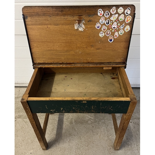 1353 - A vintage wooden child's desk with lift up lid, inkwell hole and pen tray. Raised on square legs. Ap... 