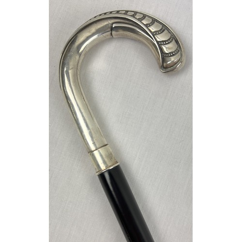 A vintage silver crook handled ebonised walking cane with embossed pattern to handle, stamped 925. Approx. 95.5cm long.