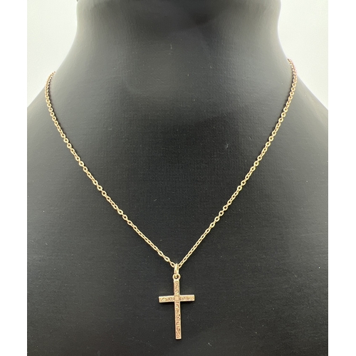 36 - A 9ct gold cross shaped pendant with front floral decoration, on a 15