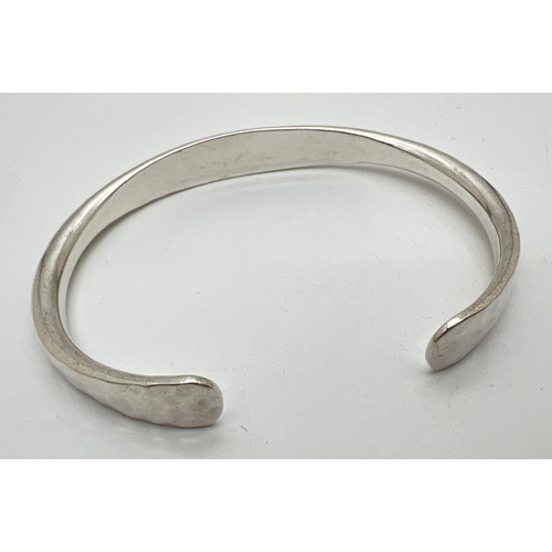 1004 - A vintage silver hammered effect cuff bangle by James Avery. Makers mark and silver mark to inside o... 