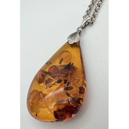 1005 - A large teardrop honey amber pendant with floral design, bale on a 24