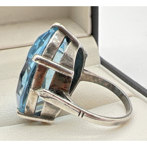 1039 - A vintage silver cocktail ring set with a large oval cut pale blue stone. Silver mark inside band. R... 