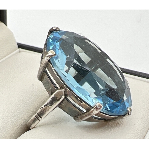 1039 - A vintage silver cocktail ring set with a large oval cut pale blue stone. Silver mark inside band. R... 