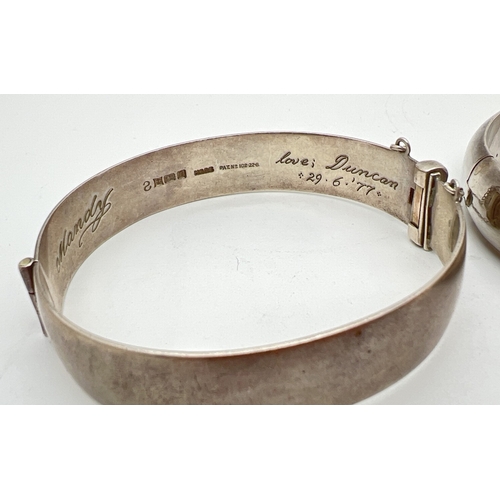 1043 - 2 vintage silver bangles. One with half floral engraved decoration and safety chain, engraved 