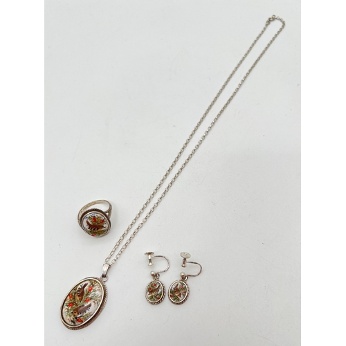 1064 - A silver pendant necklace with matching screw back earrings and ring. All set with ovals of ceramic ... 