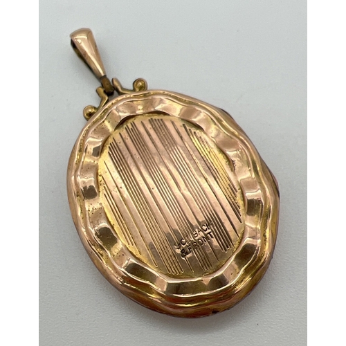 1066 - A vintage 9ct gold front and back oval shaped locket with scallop design edging. Engine turned decor... 