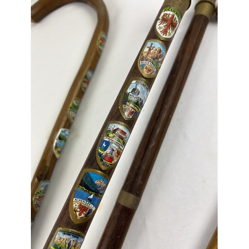 1293 - 4 vintage walking sticks to include brass handled and silver collared. A crook handled stick with Eu... 