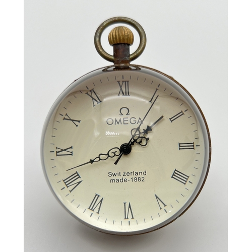 1257 - A top winding glass ball watch, bound in brass with roman numeral markers. Approx. 6cm diameter. In ... 