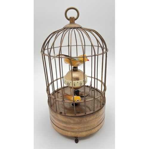 1258 - A brass ornamental wind up birdcage clock with winding mechanism to underside. Both birds move insid... 