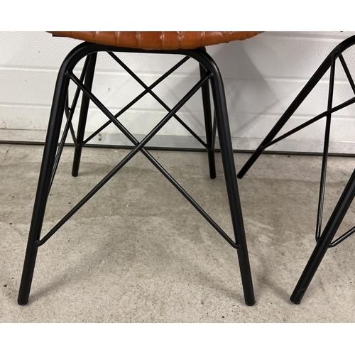 1369 - A pair of retro style black metal framed dining chairs with stitched leather seats and curved backs.... 