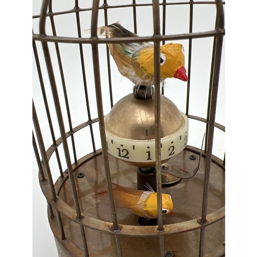 1258 - A brass ornamental wind up birdcage clock with winding mechanism to underside. Both birds move insid... 