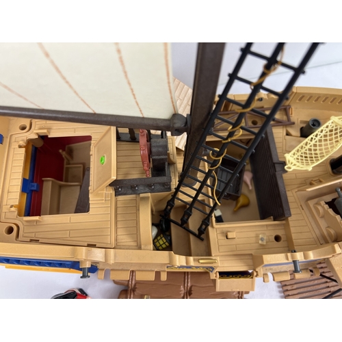 162 - A vintage Playmobile Pirate Ship with figures and accessories to include raft, cannons, furniture an... 