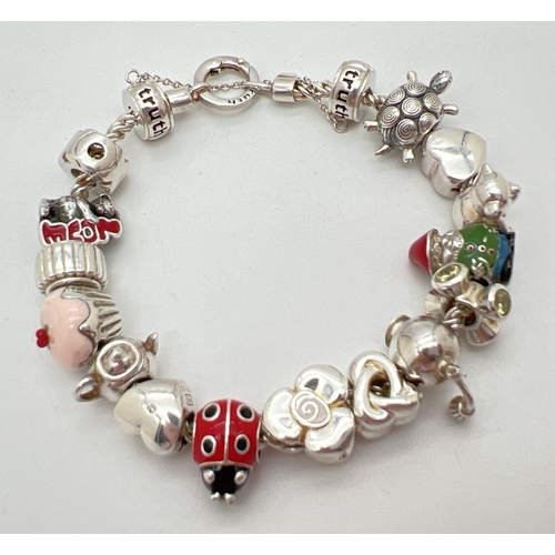 1016 - A 925 silver charm bracelet by Truth with 16 charms, some with enamel detail. Charms include double ... 