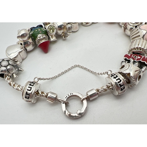 1016 - A 925 silver charm bracelet by Truth with 16 charms, some with enamel detail. Charms include double ... 