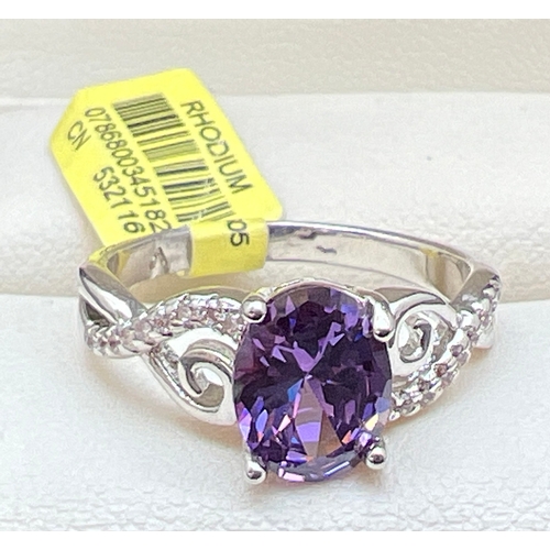 1163 - A rhodium plated cocktail ring set with Swarovski crystals, new with tags. Central purple oval cut c... 