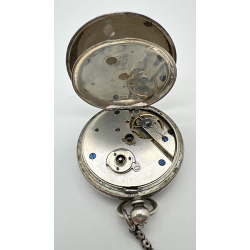 1181 - A Victorian silver cased pocket watch with white metal chain and albert. Engine turned decoration to... 