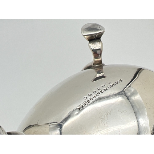 1205 - An Art Deco silver sauce boat with decorative scrolled handle and raised on tripod stepped design ho... 