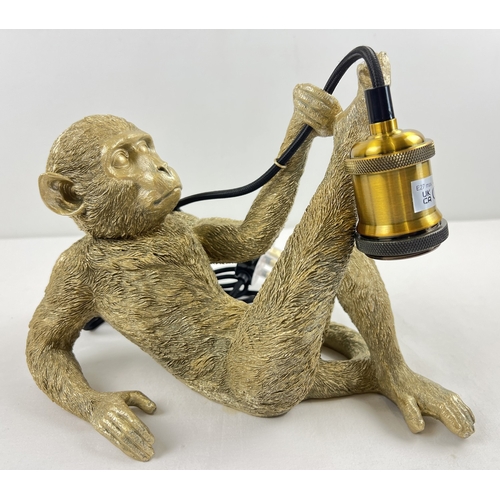 1326 - A modern gold coloured reclining monkey table lamp. Approx. 22cm tall x 31cm long.