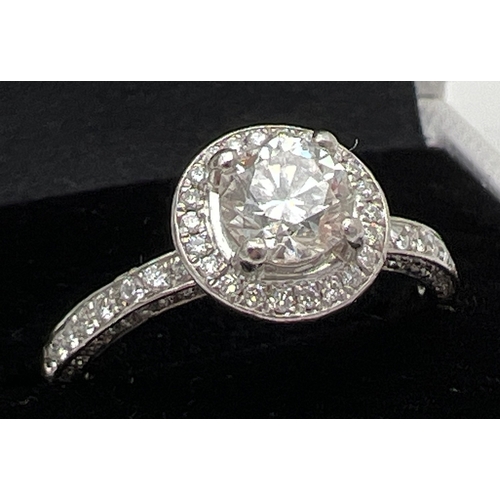 1138 - A platinum and diamond halo cluster ring with Central 0.82ct diamond. 3 rows of smaller diamonds to ... 