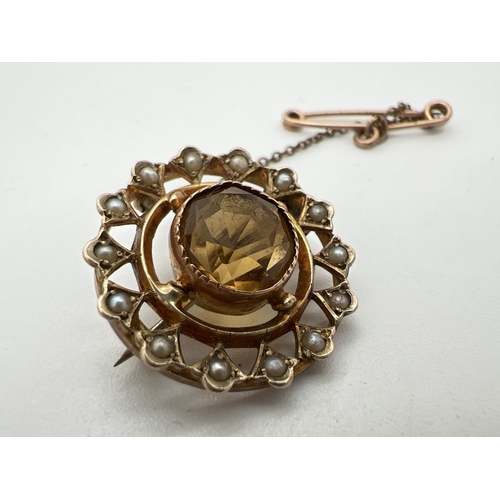 1001 - An antique 9ct gold circular brooch set with a central round cut citrine stone, surrounded by 14 see... 