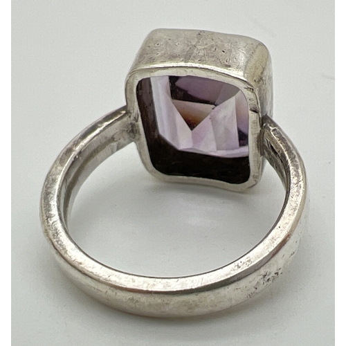 1012 - A 925 silver modern design dress ring set with a large table cut amethyst. Silver marks on inside of... 