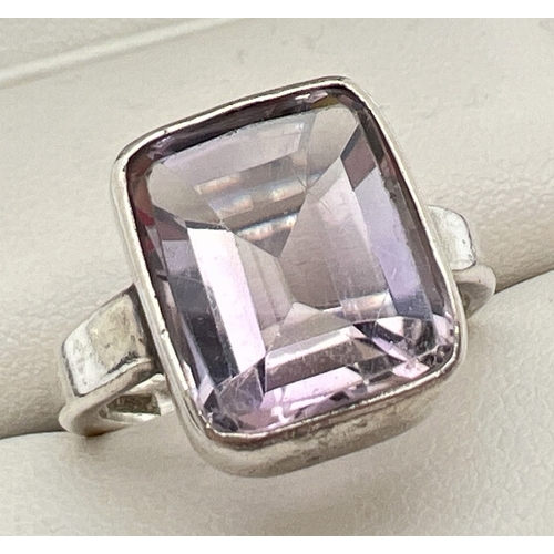 1012 - A 925 silver modern design dress ring set with a large table cut amethyst. Silver marks on inside of... 