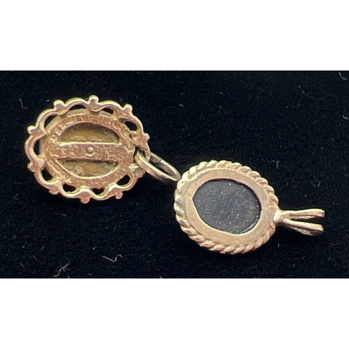 1017 - 2 small 9ct gold, oval shaped, natural stone set pendants. A rope design mount set with black onyx a... 