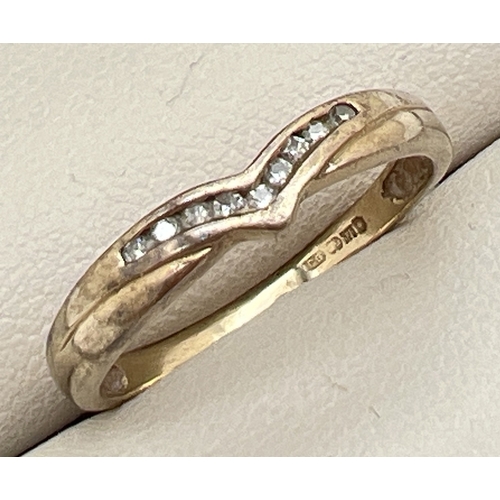 1026 - A 9ct gold wishbone ring set with 9 small round cut channel set diamonds. Hallmarked inside band. Si... 