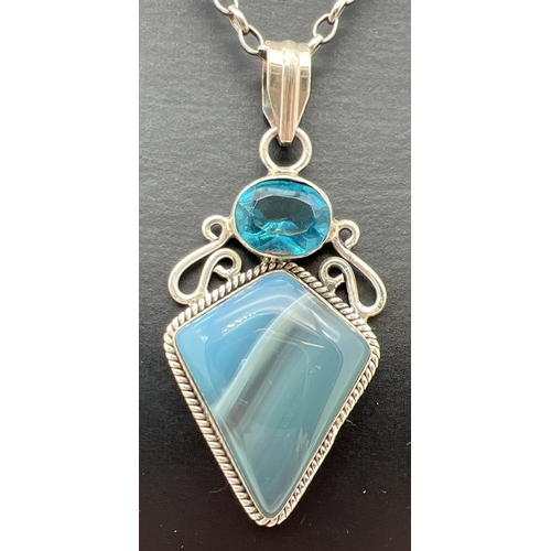 1005 - A modern design silver pendant set with a kite cut Botswana blue agate and an oval cut blue topaz. O... 