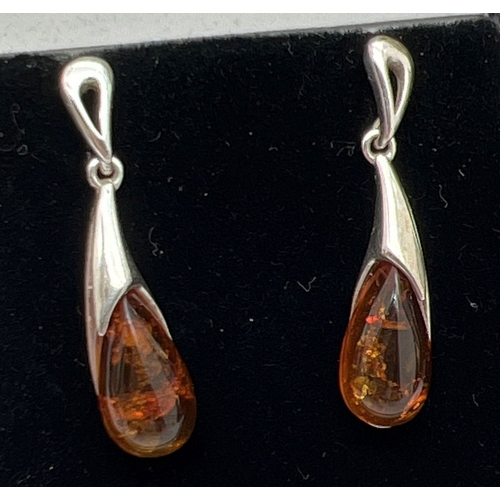 1054 - 3 pairs of silver drop style earrings. A modern design pair set with cognac amber, an Art Nouveau st... 