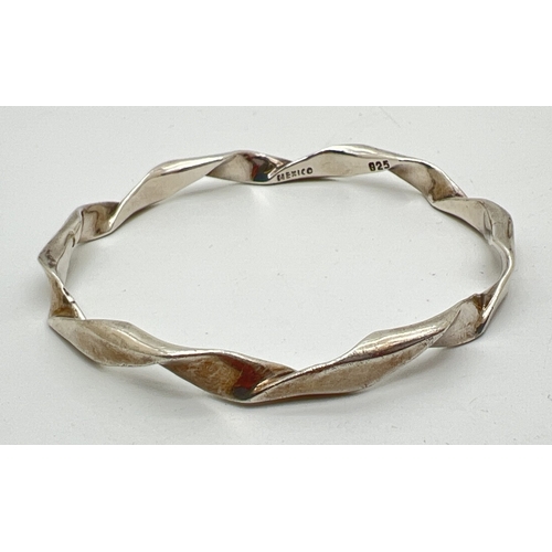 1073 - A Mexican silver twist design bangle marked Mexico 925 inside. Approx 7.5cm across, weight approx. 2... 