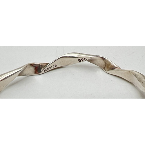 1073 - A Mexican silver twist design bangle marked Mexico 925 inside. Approx 7.5cm across, weight approx. 2... 