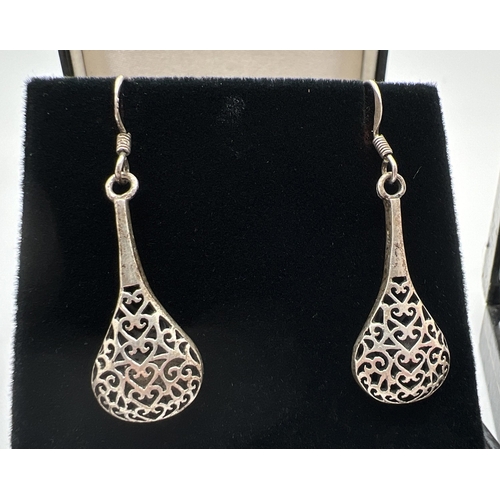 1077 - 3 pairs of silver and white metal drop style earrings with hooked posts. A pair of plain stars, a pa... 