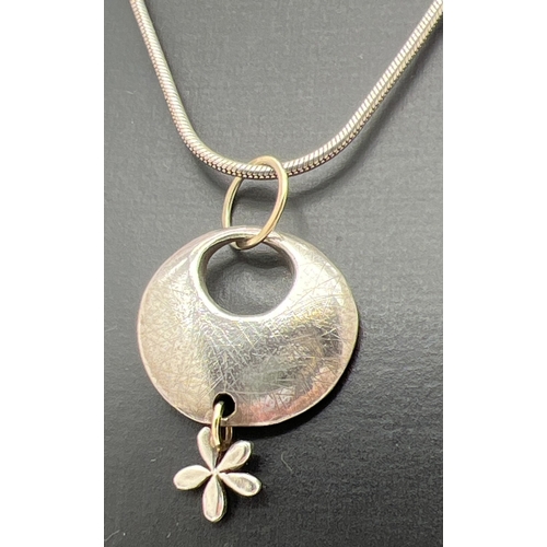 1079 - A modern design silver and 9ct gold circular shaped pendant with flower drop, by Scottish jewellery ... 