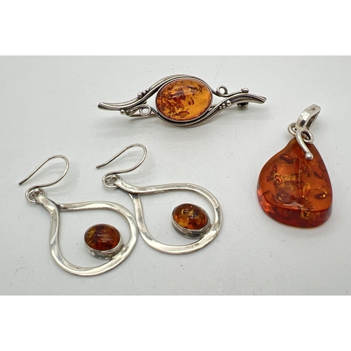 1081 - 3 items of Honey amber set silver jewellery. A brooch of an Art Nouveau style set with an oval amber... 