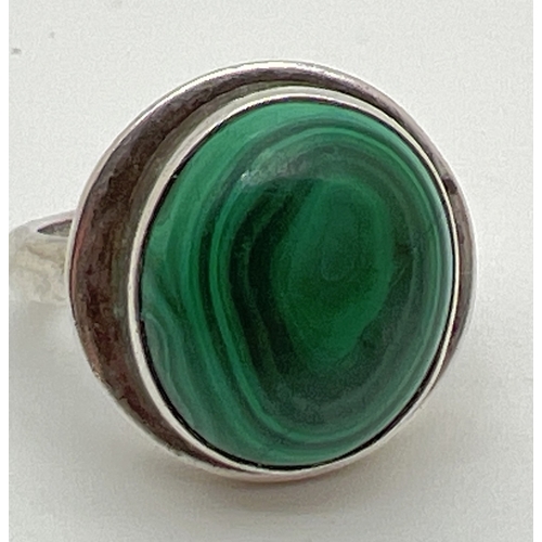 1083 - A large modern silver dress ring set with a round malachite cabochon in a stepped mount. Silver mark... 