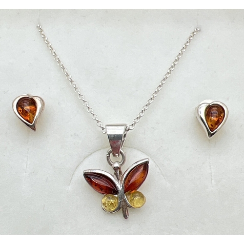 1084 - A boxed silver pendant necklace in the shape of a butterfly, set with cognac, honey and lemon amber,... 