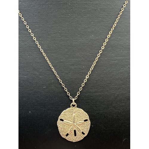 1085 - A vintage gilt sterling silver necklace by Danecraft. A circular pendant with starfish design and ha... 