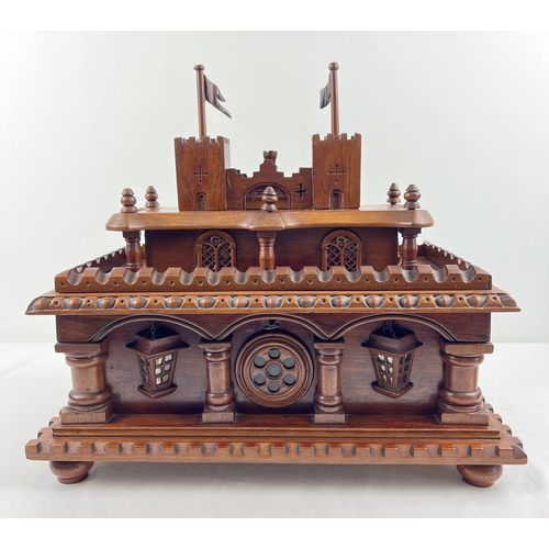 An antique rosewood large bespoke made puzzle box modelled as a castle, with several secret compartments and drawers. Highly carved detail and raised on bun feet. With key for locking main section. Approx. 40cm T x 46cm L x 27cm D.