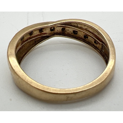 1120 - A 9ct gold and 12 point diamond eternity style ring with a twist design setting. 9 small round cut d... 