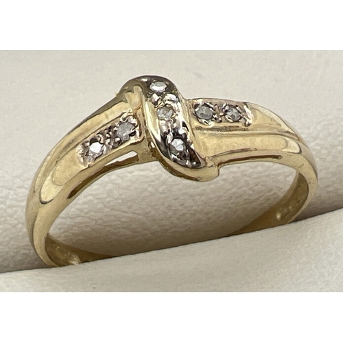 1125 - A 9ct gold and diamond set ring with a crossover design mount set with 7 small round cut diamonds. S... 