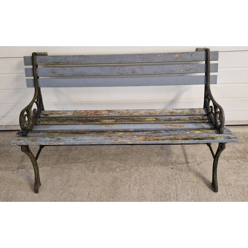 1421 - A wooden slatted garden bench with cast iron ends with scroll detail. Approx. 68cm tall x 122cm long... 