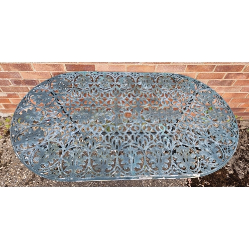 1433 - An oval shaped cast metal garden table, painted green, of scroll and foliate design. With central ho... 