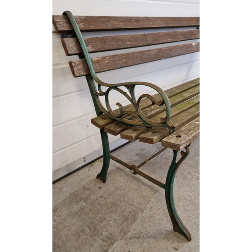 1434 - A wooden slatted garden bench with cast iron ends, painted green, with scroll detail. Approx. 122cm ... 