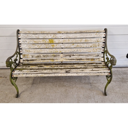 1442 - A wooden slatted garden bench with cast iron bench ends decorated with scroll design and lions head ... 