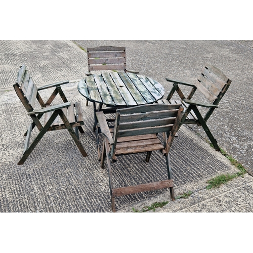 1444 - A wooden slatted garden table and matching chairs, originally painted green. Circular shaped folding... 