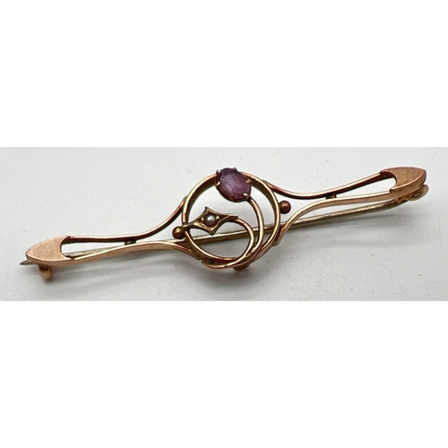 1132 - A 9ct gold Edwardian bar brooch set with a small oval cut amethyst and a seed pearl, in an Art Nouve... 