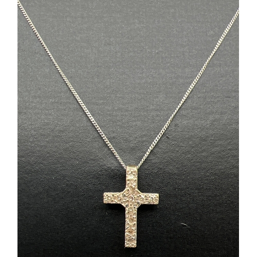 1133 - A small 9ct white gold diamond set cross pendant necklace. Cross pendant (1.25cm long) set with 11 s... 