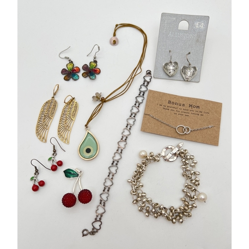 1016 - A small collection of silver, white metal and costume jewellery. To include a glass 