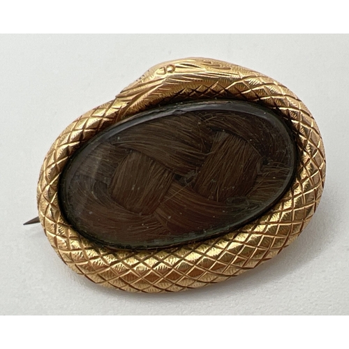 1110 - A Georgian gold Ouroboros mourning brooch with glazed central panel enclosing a lock of plaited hair... 